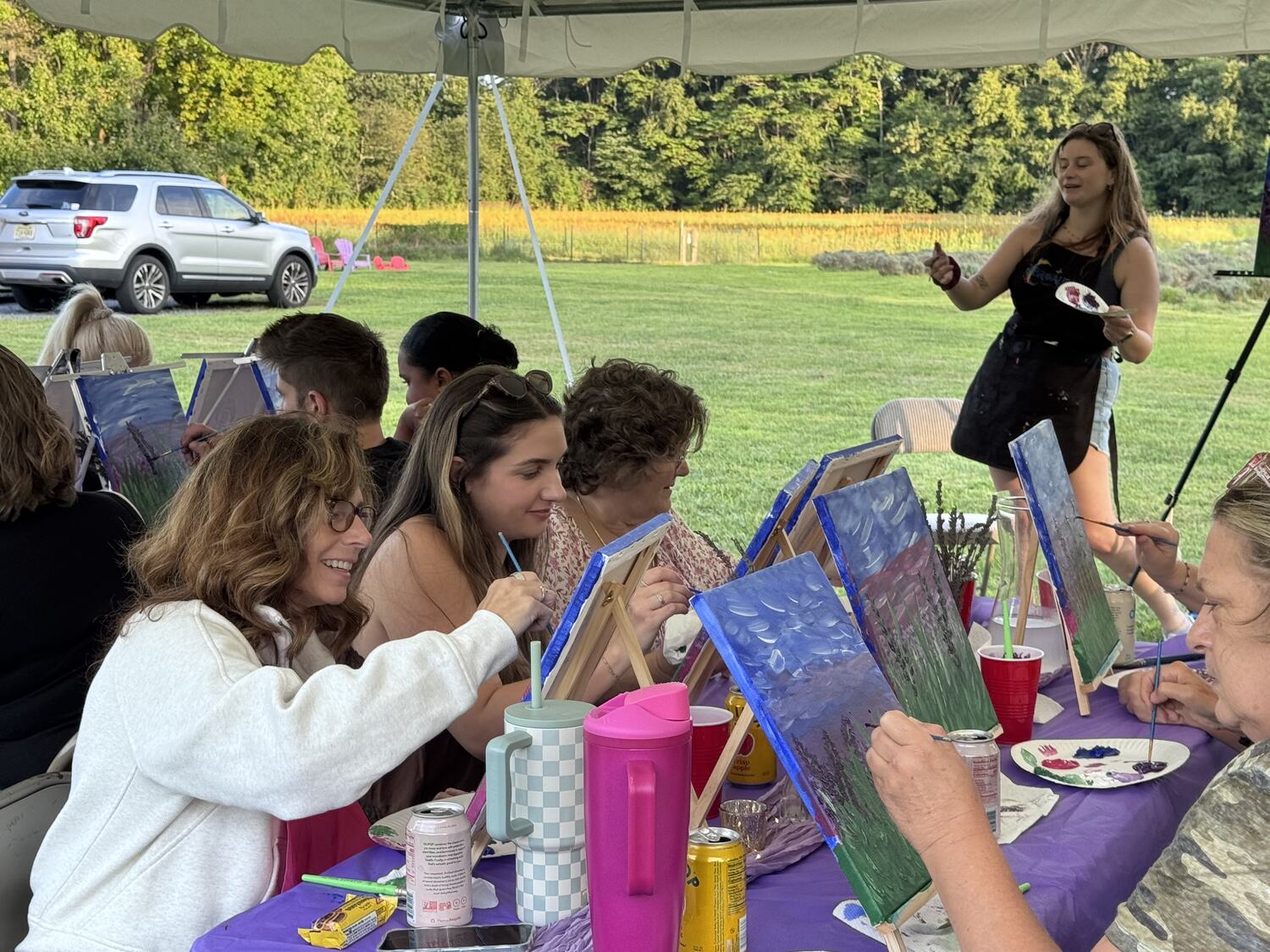 Adults laughing at a Bravaura paint and sip night